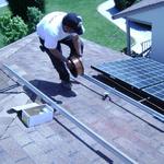 an installation team member running copper wires connecting all the Solar panels of the array together