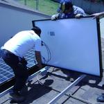 team members connecting wires and mounting the Solar panels onto the rails